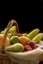 Vertical Closeup detail on a basket full of fruit on a dark background